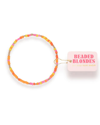 Colorful beaded hair tie with a pink packaging label on a white background