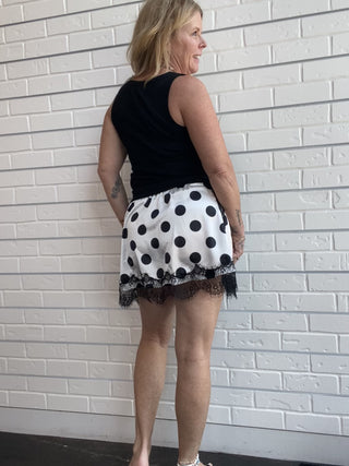 Polka Dot Lace Skirt at Ellipsis Boutique. A flowy satin skirt with a polka dot pattern, stretchy waist, and lace trim.