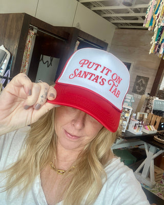 red trucker hat "put it on santas tab"