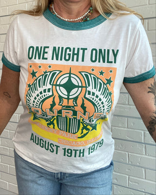 A woman wearing a white ringer t-shirt with teal trim and a large orange and green graphic on the front that reads 'ONE NIGHT ONLY BURNE August 19th 1979'.