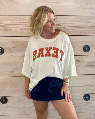 white t-shirt with 'TEXAS' printed in orange 