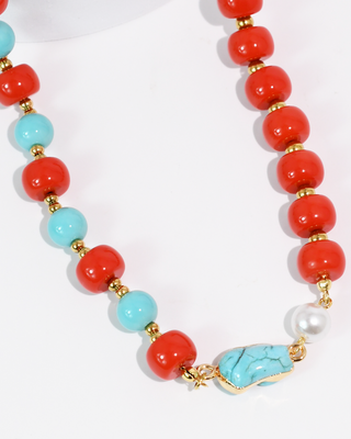 Necklace with red, turquoise, and white beads on a white background
