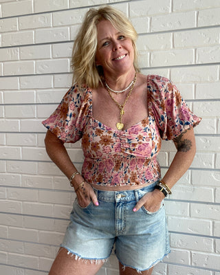 Women's floral sweetheart crop top with a square neckline, flowy sleeves, smocked back, and multicolor floral print.