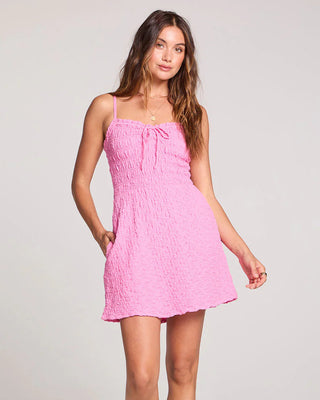 Woman wearing a pink dress on a plain background