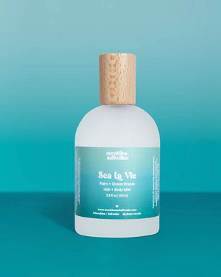 Bottle of 'Sea La Vie' product with a wooden cap on a teal background