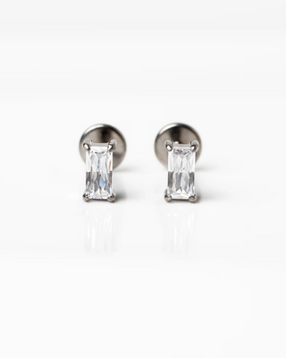 Pair of silver stud earrings with baguette-cut gemstones on a white background