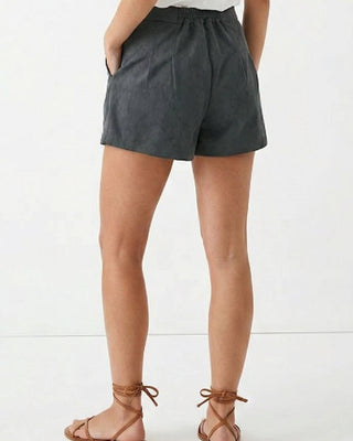 Person wearing dark gray shorts on a white background