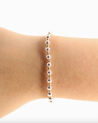 Silver beaded bracelet on a wrist against a white background