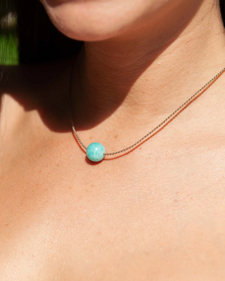 Close-up of a turquoise bead necklace on a person's neck