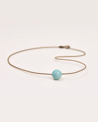 Necklace with a turquoise bead on a white background