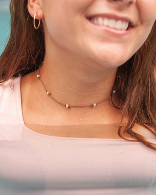 Woman wearing a pearl necklace with a blurred background