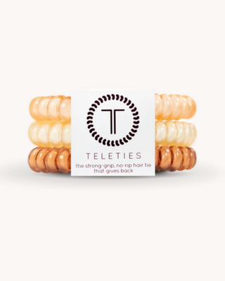 Three beige hair ties stacked on a white background with 'Teleties' branding.