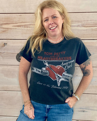 Woman wearing a graphic t-shirt in front of a wooden wall