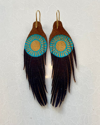 Pair of feather earrings with circular designs on a light gray background