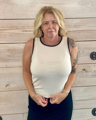 Woman standing against a wooden wall with a neutral expression