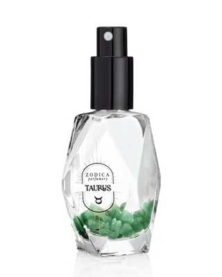 Perfume bottle labeled 'Zodica Perfumery Taurus' with green crystals on a white background